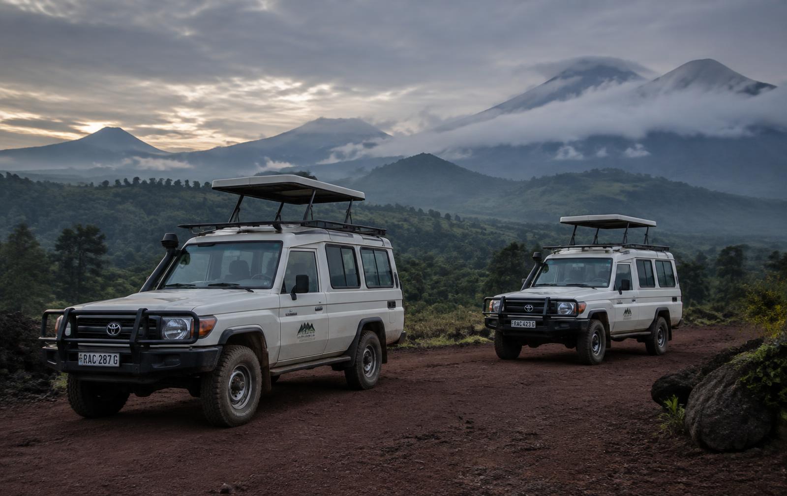 Customised 4x4 safari Land Cruisers at dawn below the Virunga volcanoes